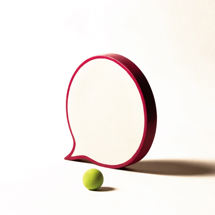 Un fumetto color crema con il bordo fucsia e davanti una piccola sfera lime